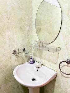 a bathroom with a white sink and a mirror at Garden Cottage Homestay BB in Wattala