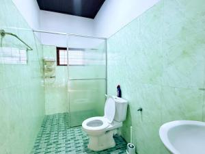a bathroom with a toilet and a sink at Garden Cottage Homestay BB in Wattala