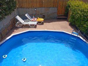 a small blue swimming pool with a table and chairs at Refúgio Da Pinheira in Marco de Canaveses