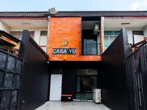 an orange and black building with a sign on it at Casa Yu in Hat Yai
