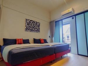 a bedroom with a bed and a large window at Casa Yu in Hat Yai