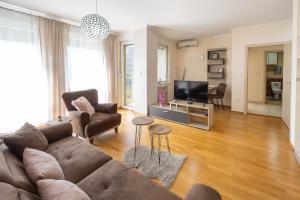 a living room with a couch and a tv at Apartment Orchid 021 in Novi Sad
