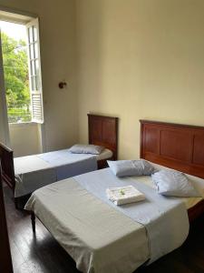 two beds in a bedroom with a window at Hotel Valenciano in Valença