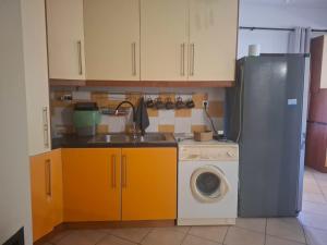 a kitchen with a sink and a washing machine at Le Rocher 3 in Ermoupoli