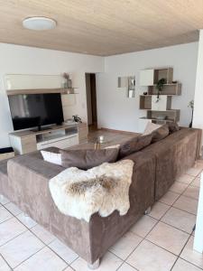 a large brown couch in a living room with a television at Angolo del Tramonto in Gambarogno +43 photos