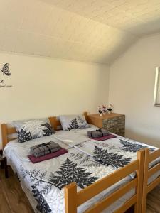 a bedroom with a large bed with black and white sheets at Fruškogorska bajka in Velika Remeta +28 photos