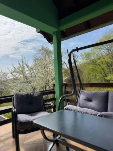 a table and two chairs on a porch with a view at Fruškogorska bajka in Velika Remeta