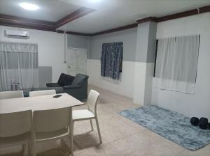 a living room with a table and chairs and a couch at hatyai homestay greenway orkar in Hat Yai