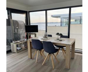 a wooden table and chairs in a room with a television at Floating 44 in Xanten - Boot 2 in Xanten