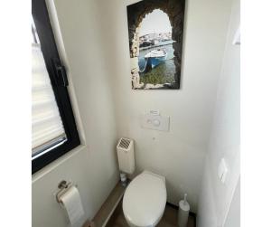 a bathroom with a toilet and a picture on the wall at Floating 44 in Xanten - Boot 2 in Xanten
