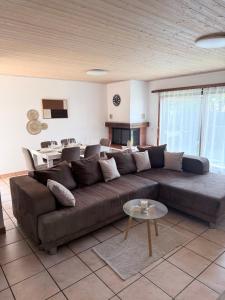 a living room with a brown couch and a table at Angolo del Tramonto in Gambarogno