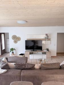 a living room with a couch and a flat screen tv at Angolo del Tramonto in Gambarogno