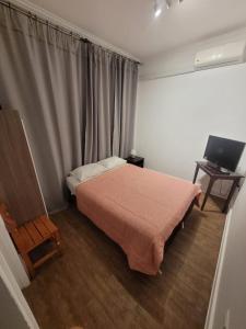 a small bedroom with a bed and a television at Hotel Traslaviña in Viña del Mar