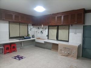 a kitchen with wooden cabinets and a counter top at hatyai homestay greenway orkar in Hat Yai +22 photos