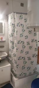a bathroom with a shower curtain with tiles on the wall at Adikati Lak in Bük +12 photos