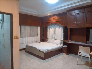 a bedroom with a bed and a desk and a chair at hatyai homestay greenway orkar in Hat Yai