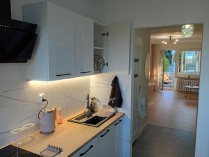 a kitchen with white cabinets and a sink at Apartament Niebieskie in Zamość