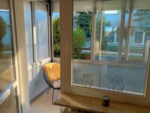 a screened in porch with windows with white blinds at Apartament Niebieskie in Zamość