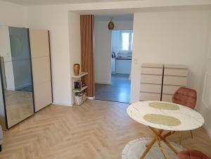 a living room with a table and a kitchen at Apartament Niebieskie in Zamość