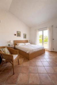 a bedroom with a bed and a chair and a window at La casa di Fedra in Imperia