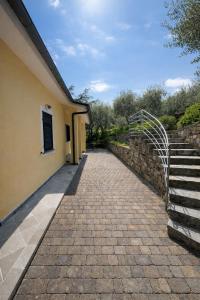 a brick walkway next to a stone wall and stairs at La casa di Fedra in Imperia