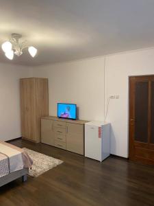 a bedroom with a bed and a tv and a refrigerator at Casa Noel in Târgu Ocna