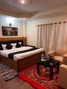 a bedroom with a bed and a couch and a table at Hexon Stays in Manāli
