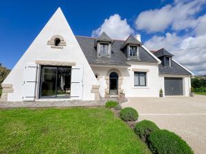 a white house with a pointed roof at Ty ar Vigouden - maison de vacances in Loctudy