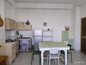 a kitchen with a table and a refrigerator at Adamo Flat in Bisciano