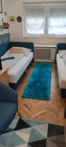 a room with two beds and two rugs on the floor at Adikati Lak in Bük