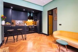 a living room with a couch and a kitchen at Edinburgh Centre - Holyrood Apartment in Edinburgh