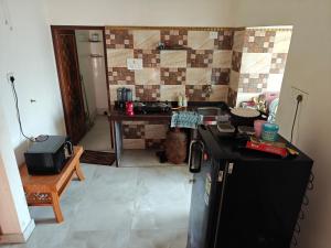 a kitchen with a black refrigerator and a sink at Perfect for Homely Atmosphere in kolkata