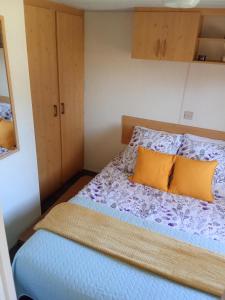 a small bedroom with a bed with yellow pillows at Le Bruant des Roseaux in Villegusien Le Lac