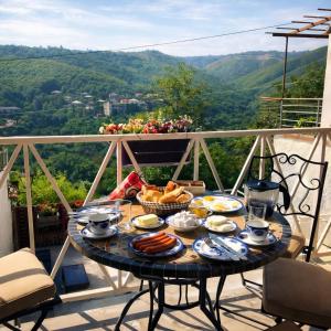 a table with plates of food on a balcony at Sighnaghi Art Hotel in Sighnaghi
