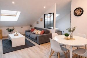 a living room with a couch and a table at Charmant Loft climatisé 50 m de la gare in Chalon-sur-Saône
