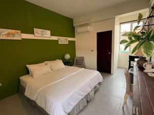 a bedroom with a green wall with a bed at Baiput Ayutthaya, Self check-in in Phra Nakhon Si Ayutthaya