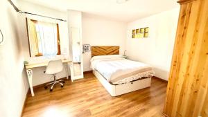 a bedroom with a bed and a desk and a chair at Casa Rural NEREA in Letux