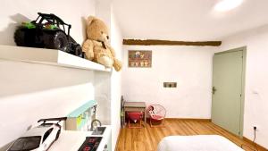a bedroom with a bed and a teddy bear on a shelf at Casa Rural NEREA in Letux