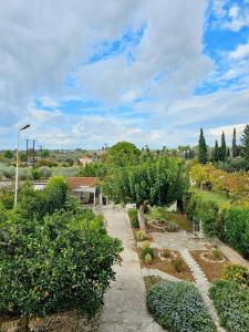 a garden with trees and bushes and a sidewalk at Sophy's Cottage in Politika