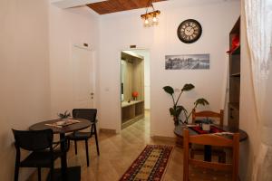 a dining room with a table and chairs and a clock on the wall at Enma Rooms in Krujë