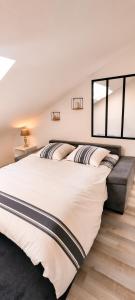 a bedroom with a large white bed and two windows at Charmant Loft climatisé 50 m de la gare in Chalon-sur-Saône