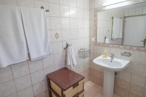 a white bathroom with a sink and a mirror at Xenia's House in Kefalos +45 photos