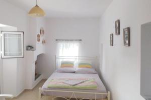 a bedroom with a bed in a white room at Xenia's House in Kefalos