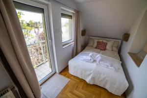 a small bedroom with a bed and a window at Dunai Menedék in Ráckeve