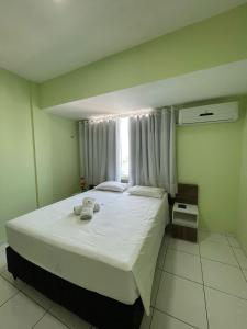 ein Schlafzimmer mit einem großen weißen Bett und einem Fenster in der Unterkunft Hotel Letiva Arco in Sobral