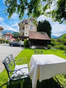 a table and chairs in front of a building at Hotel De La Paix in Interlaken