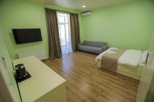 a hotel room with a bed and a television at Prime Heaven in Chiatʼura
