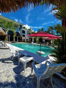 a swimming pool with chairs and an umbrella at Show Pony Ranchero Resort - Boutique Beach Hotel in Las Lajas