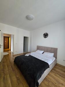 a bedroom with a large bed with a black blanket at White Ribbon Prizren in Prizren