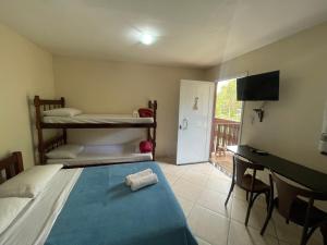 a bedroom with a bed and a desk and a bunk bed at Flat Salto Dagua Penedo in Penedo